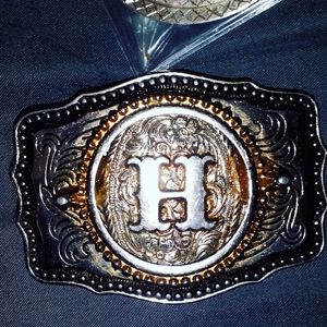 Silver men's belt buckle with the H intial in the middle of it